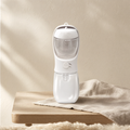 Portable pet water bottle in white on a pale oak table in soft morning light